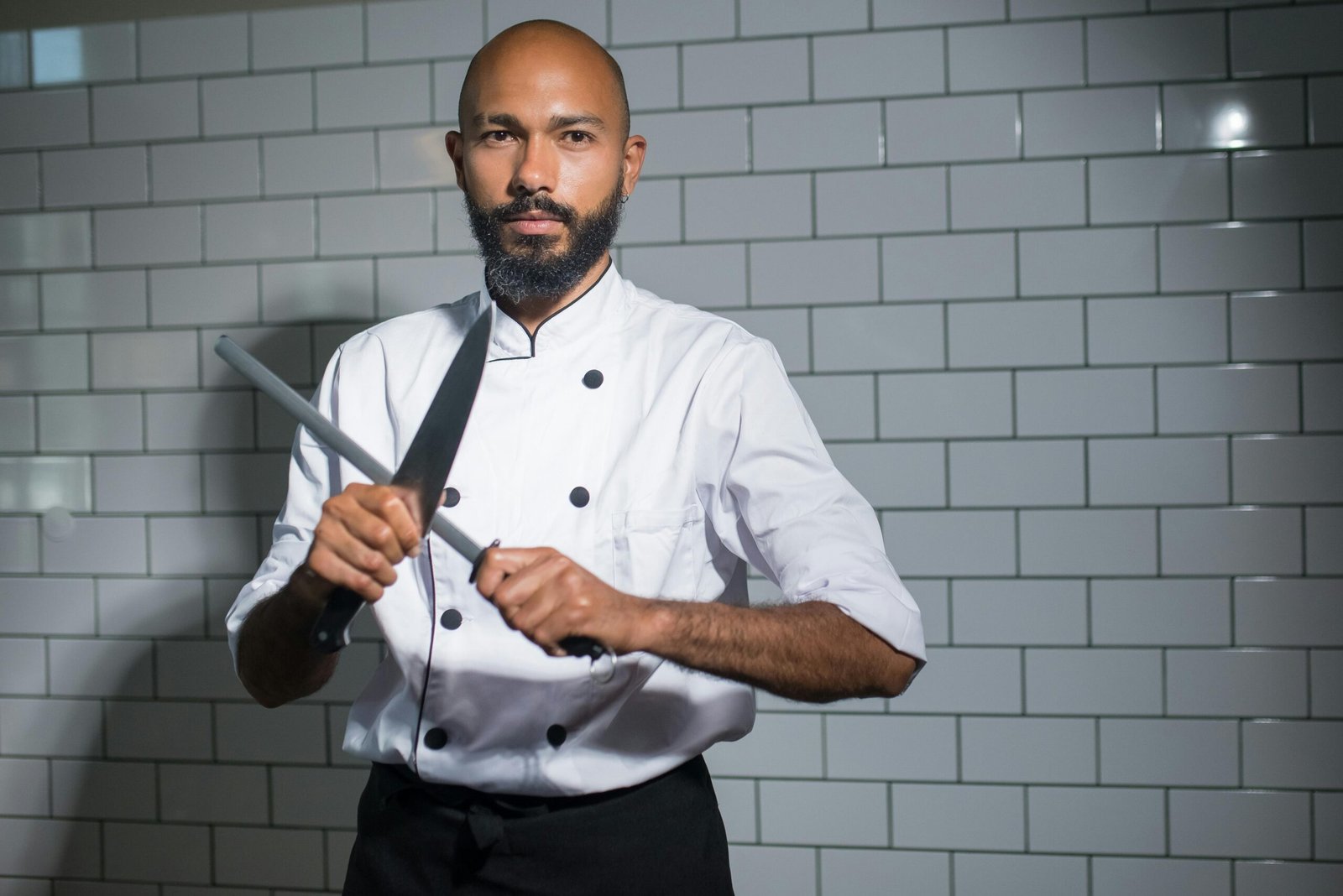 A skilled chef sharpening a knife in a modern kitchen, highlighting culinary precision.